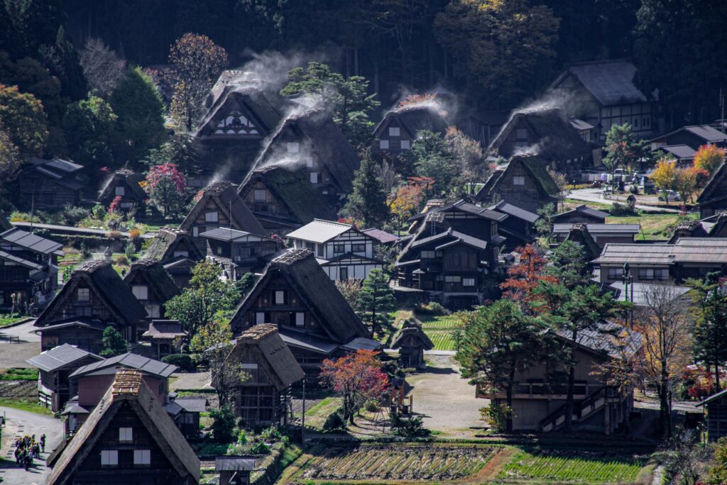 白川郷 日が当たり始めて湯気を上げる合掌造りの茅葺き屋根